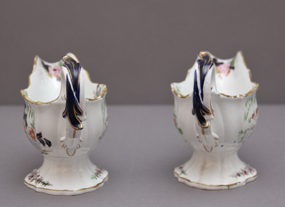 A pair of early nineteenth-century white porcelain sauceboats decorated with hand-painted floral motifs, cobalt blue accents, and gilded scalloped rims. View IV