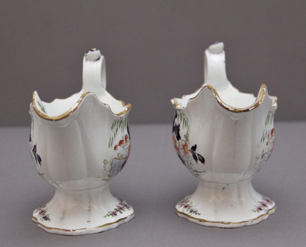 A pair of early nineteenth-century white porcelain sauceboats decorated with hand-painted floral motifs, cobalt blue accents, and gilded scalloped rims. View VI