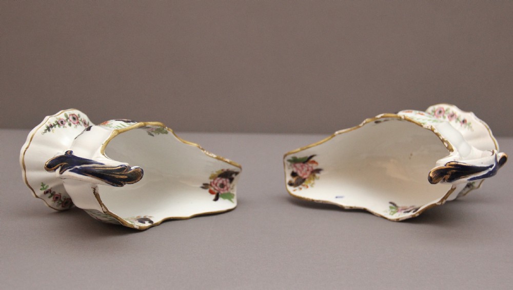A pair of early nineteenth-century white porcelain sauceboats decorated with hand-painted floral motifs, cobalt blue accents, and gilded scalloped rims. View VII