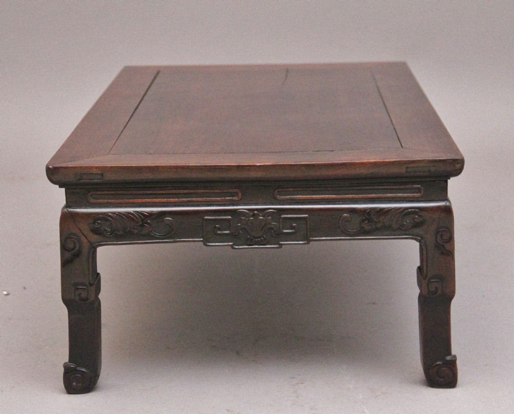 A 19th-century Chinese carved dark wood low table with a floating panel top and stylized scroll feet. View IV
