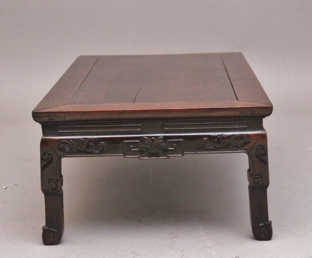 A 19th-century Chinese carved dark wood low table with a floating panel top and stylized scroll feet. View VI