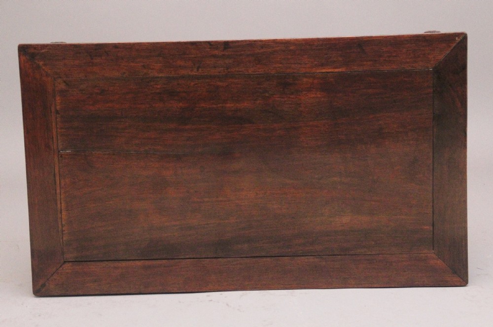 A 19th-century Chinese carved dark wood low table with a floating panel top and stylized scroll feet. View VII