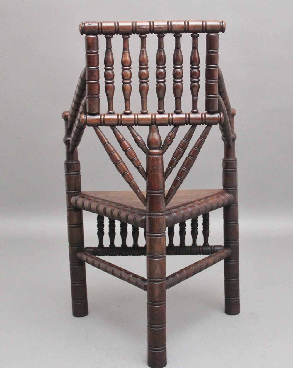 A 19th-century dark oak turners chair featuring a triangular seat, intricate bobbin-turned backrest, and sturdy turned wooden legs. View IV