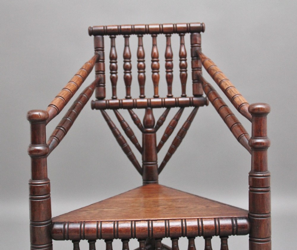 A 19th-century dark oak turners chair featuring a triangular seat, intricate bobbin-turned backrest, and sturdy turned wooden legs. View VIII