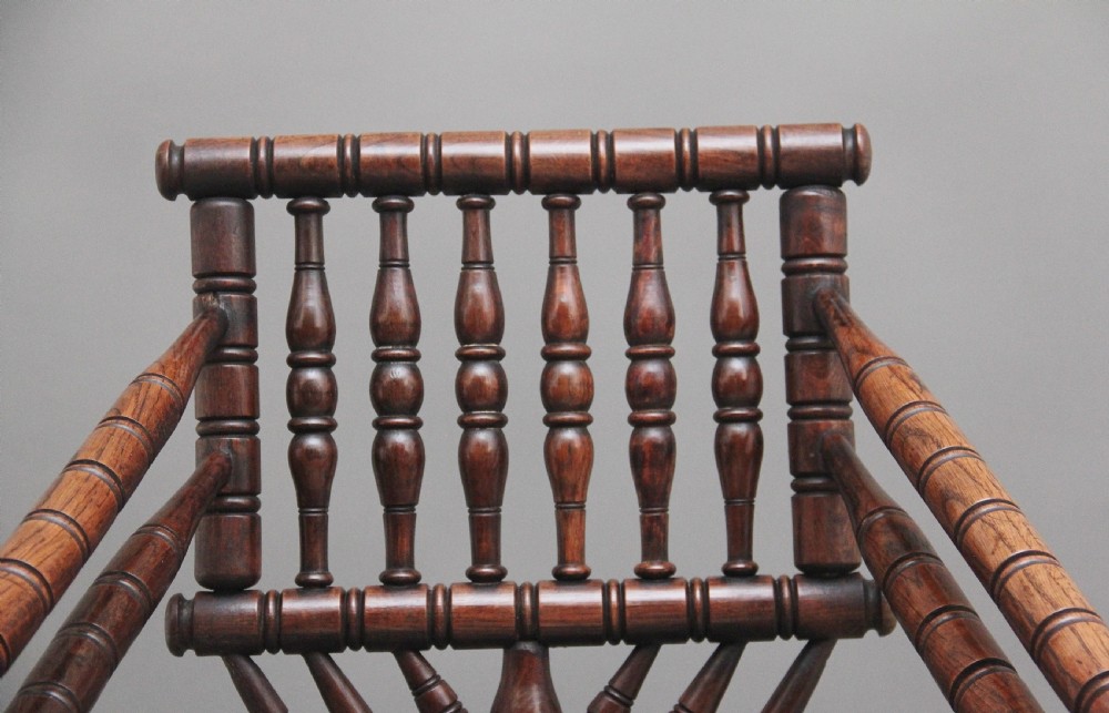 A 19th-century dark oak turners chair featuring a triangular seat, intricate bobbin-turned backrest, and sturdy turned wooden legs. View IX