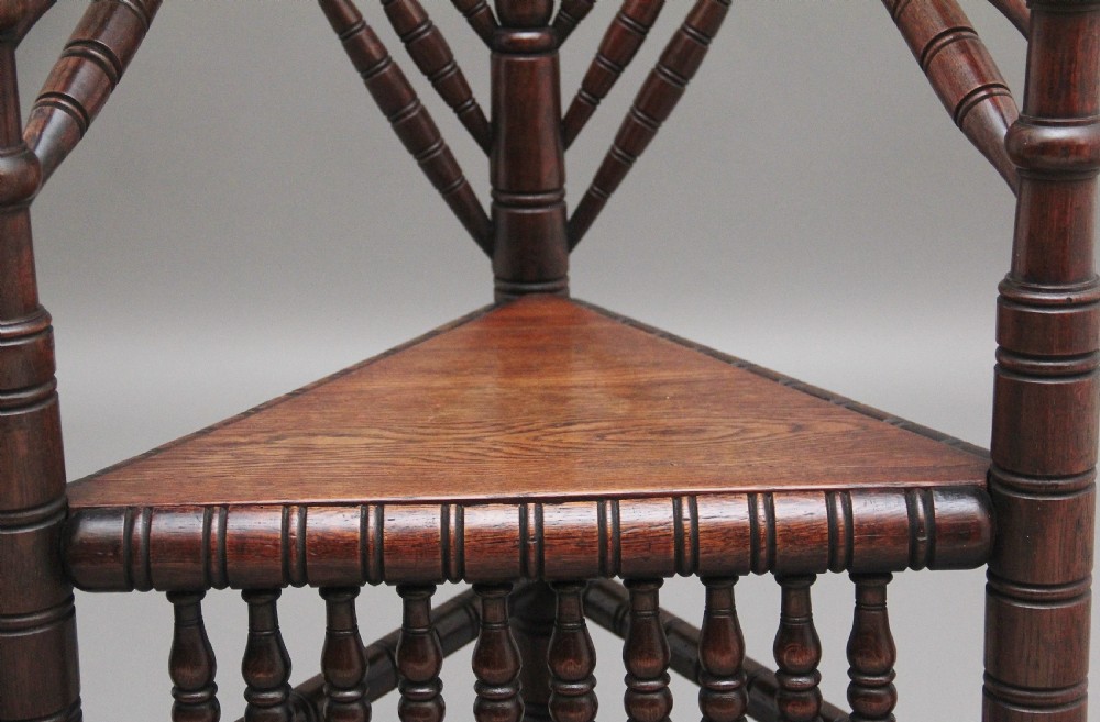 A 19th-century dark oak turners chair featuring a triangular seat, intricate bobbin-turned backrest, and sturdy turned wooden legs. View X