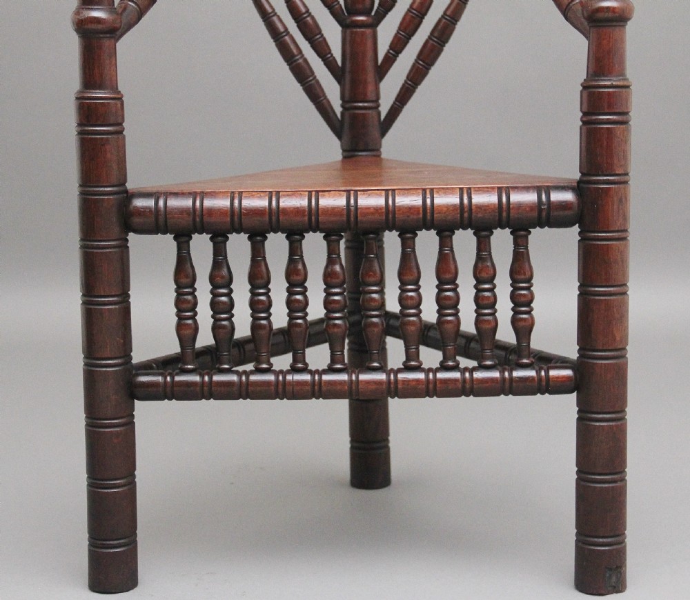 A 19th-century dark oak turners chair featuring a triangular seat, intricate bobbin-turned backrest, and sturdy turned wooden legs. View XI