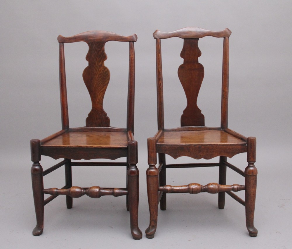A pair of 18th-century elm side chairs featuring shaped top rails, vasiform back splats, solid wooden seats, and turned front legs with stretchers. View II