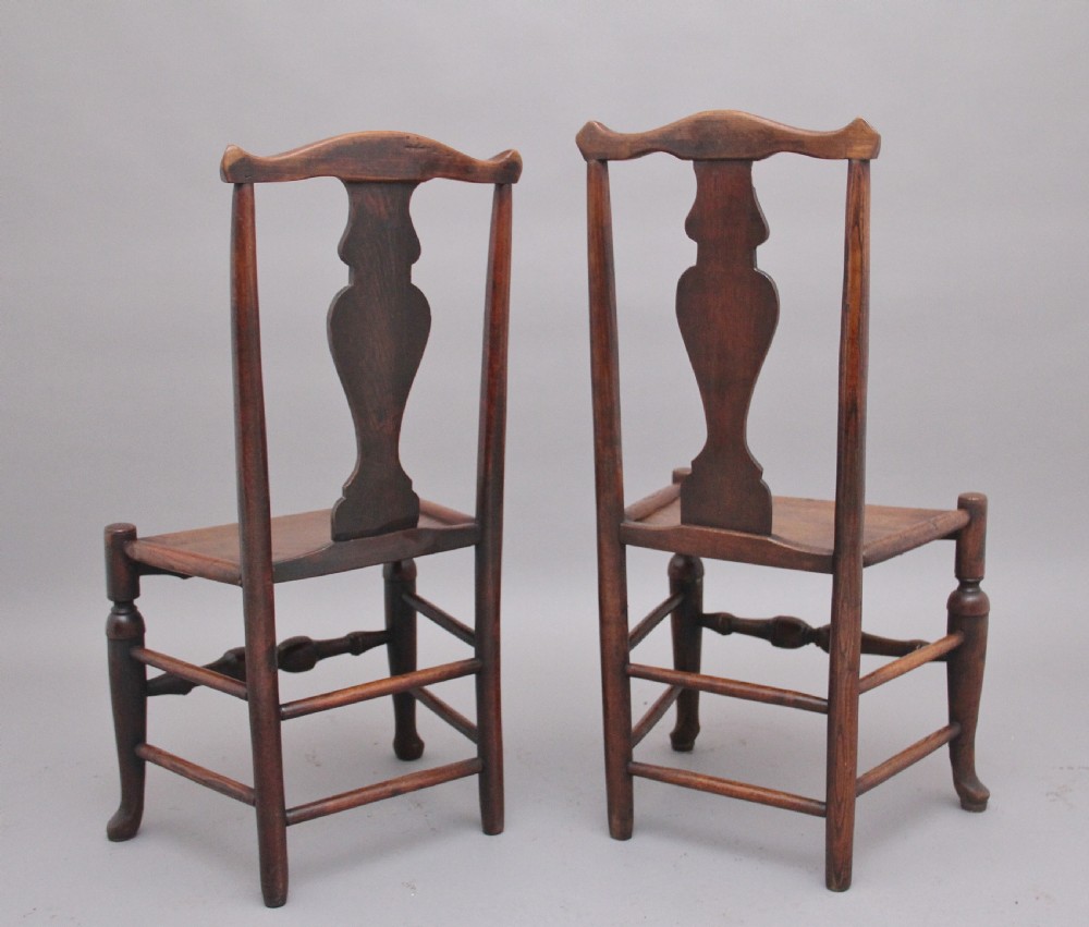 A pair of 18th-century elm side chairs featuring shaped top rails, vasiform back splats, solid wooden seats, and turned front legs with stretchers. View IV