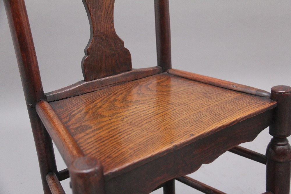 A pair of 18th-century elm side chairs featuring shaped top rails, vasiform back splats, solid wooden seats, and turned front legs with stretchers. View VI