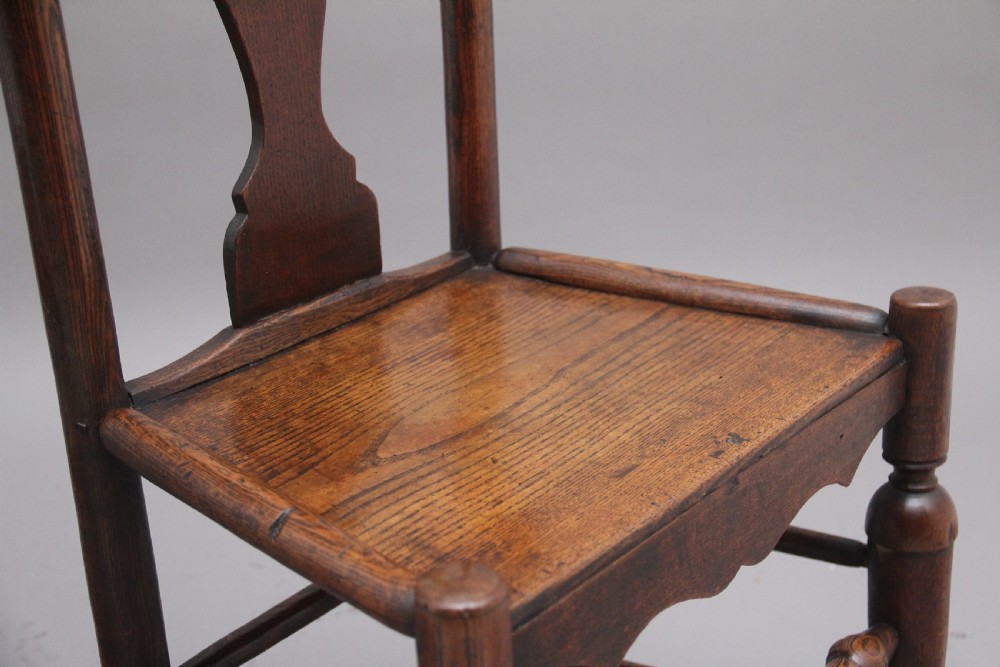A pair of 18th-century elm side chairs featuring shaped top rails, vasiform back splats, solid wooden seats, and turned front legs with stretchers. View IX