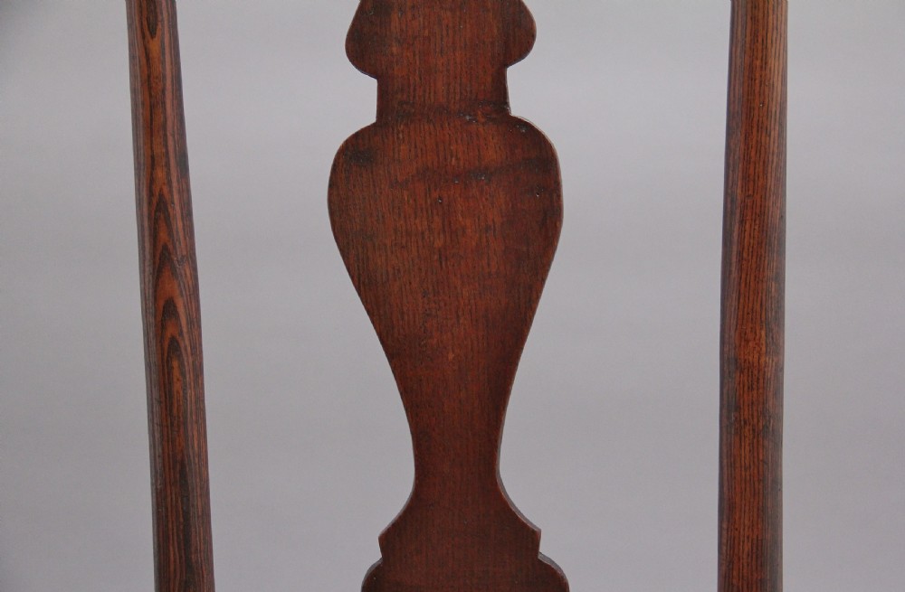 A pair of 18th-century elm side chairs featuring shaped top rails, vasiform back splats, solid wooden seats, and turned front legs with stretchers. View X