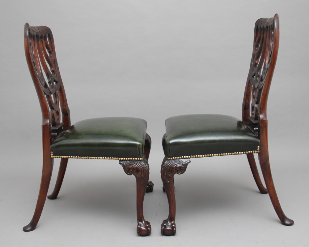 A pair of 19th-century mahogany side chairs featuring pierced carved splats, green leather seats with brass studs, and cabriole legs with ball-and-claw feet. View II