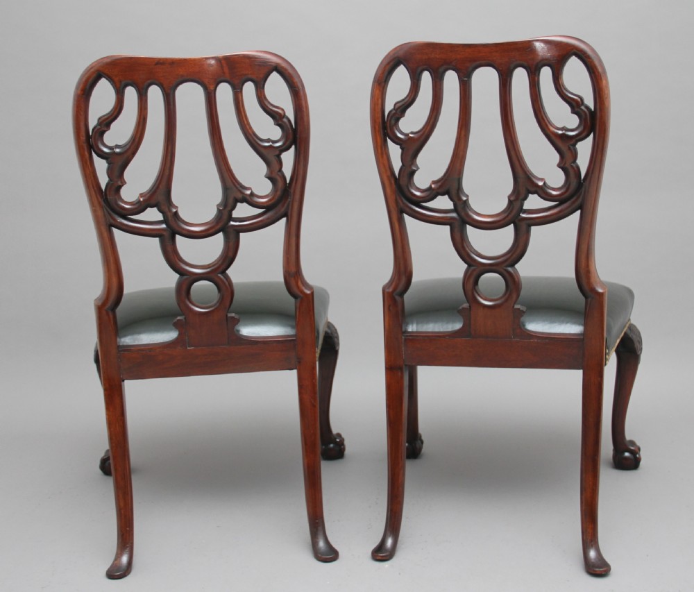 A pair of 19th-century mahogany side chairs featuring pierced carved splats, green leather seats with brass studs, and cabriole legs with ball-and-claw feet. View III