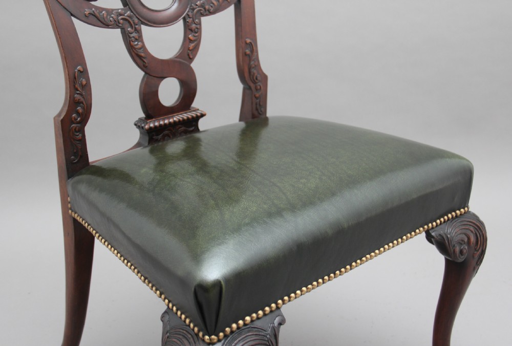 A pair of 19th-century mahogany side chairs featuring pierced carved splats, green leather seats with brass studs, and cabriole legs with ball-and-claw feet. View VI