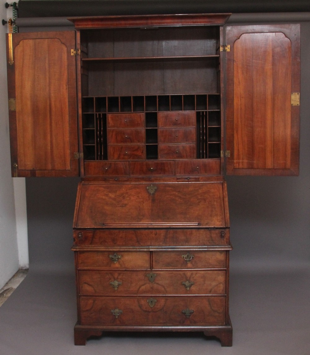 An early 18th-century walnut bureau bookcase featuring a slant-front writing desk base over drawers and an upper cabinet with two mirrored doors. View III