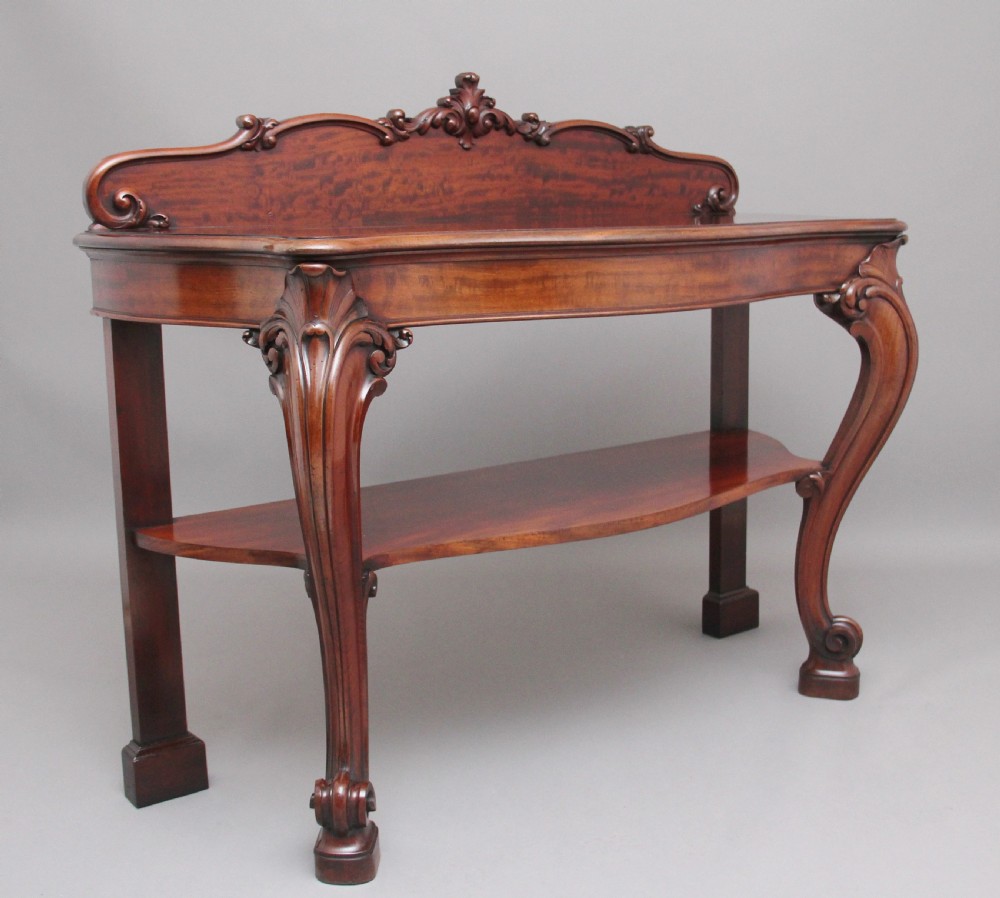 A 19th-century mahogany serving table featuring a carved back gallery, curved cabriole legs, and a lower tier shelf. View II
