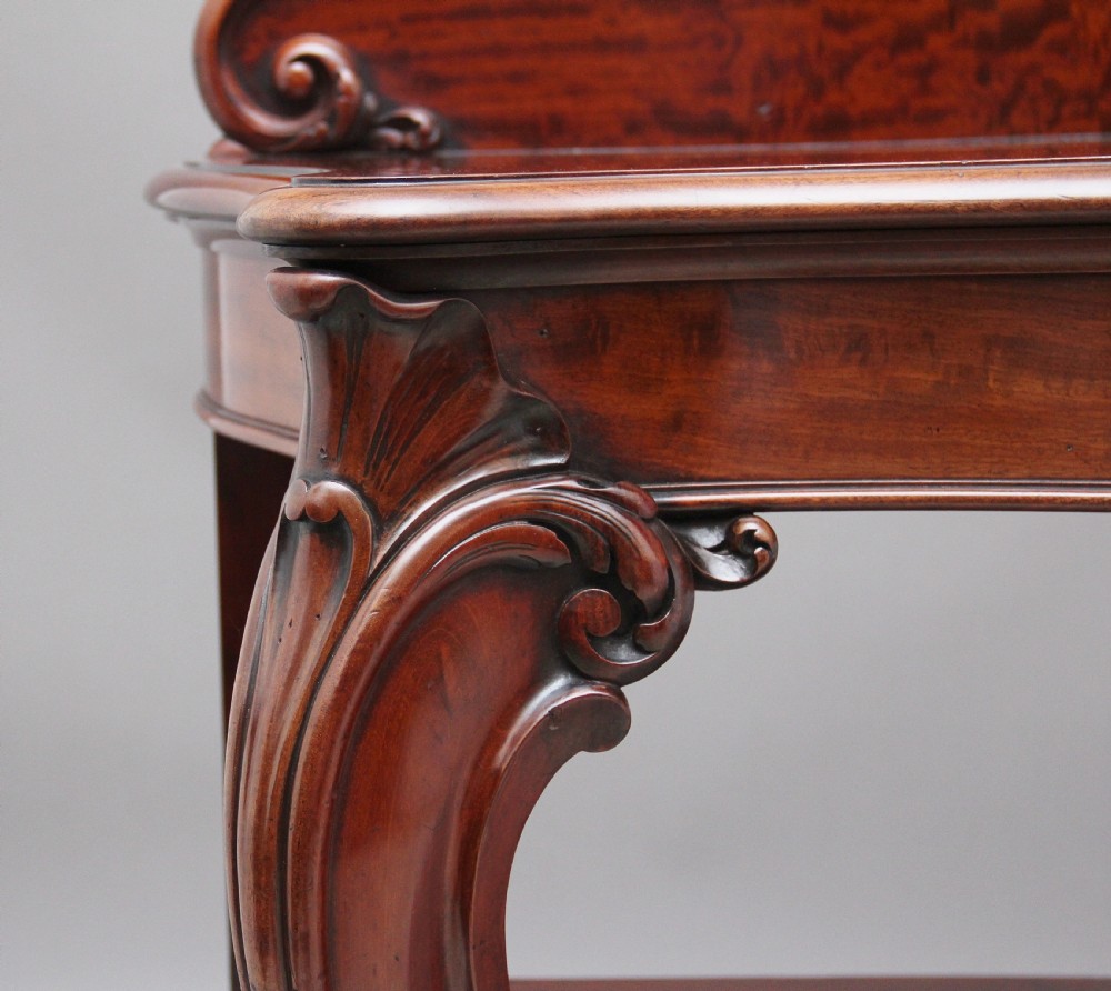 A 19th-century mahogany serving table featuring a carved back gallery, curved cabriole legs, and a lower tier shelf. View VII