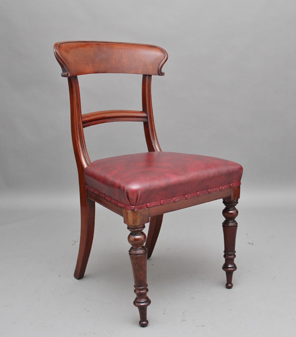 A set of twelve nineteenth-century mahogany dining chairs featuring curved top rails, turned front legs, and red leather upholstered seats with studding. View III