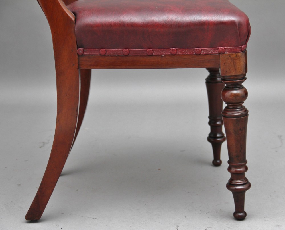 A set of twelve nineteenth-century mahogany dining chairs featuring curved top rails, turned front legs, and red leather upholstered seats with studding. View VIII