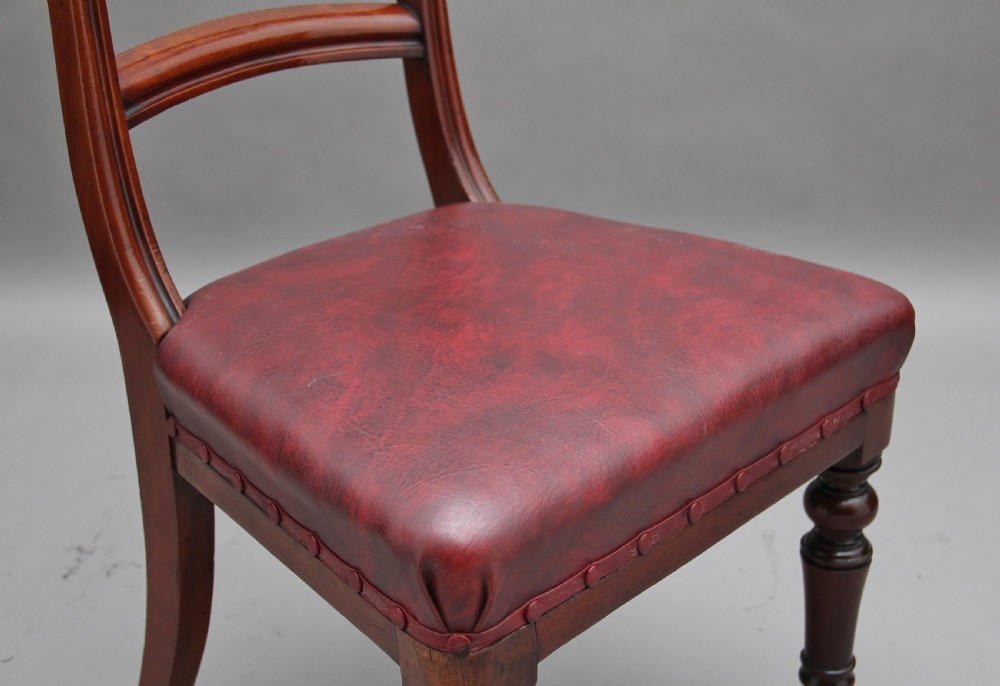 A set of twelve nineteenth-century mahogany dining chairs featuring curved top rails, turned front legs, and red leather upholstered seats with studding. View XI