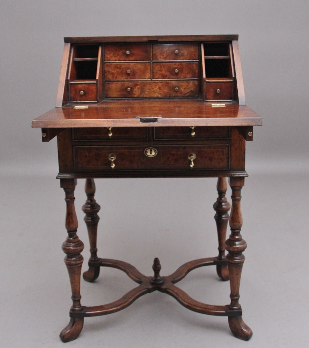 An early 20th-century walnut writing bureau on stand with a sloped fall front, lower drawers, and turned legs with a shaped cross-stretcher. View IV