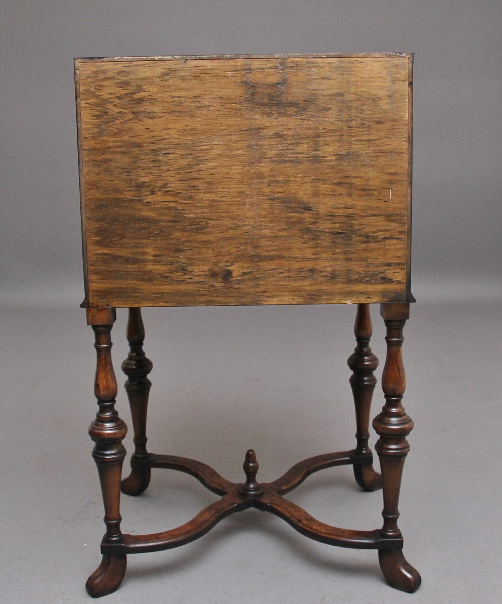 An early 20th-century walnut writing bureau on stand with a sloped fall front, lower drawers, and turned legs with a shaped cross-stretcher. View X