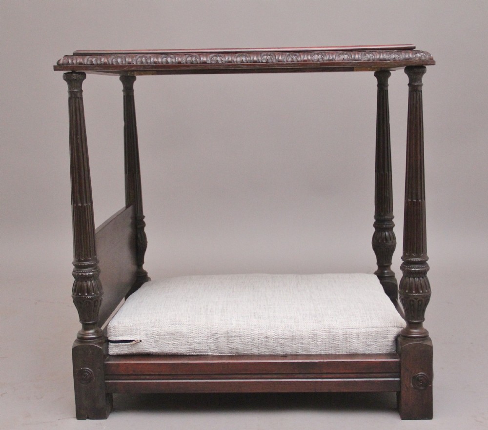 A nineteenth-century mahogany four-poster dog bed featuring carved reeded posts, a moulded canopy frame, and a neutral fabric cushion. View II