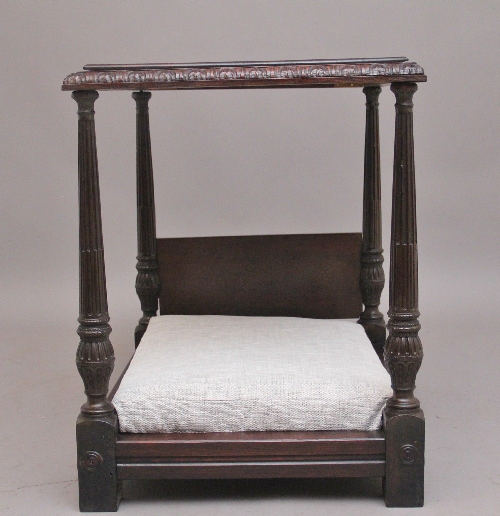 A nineteenth-century mahogany four-poster dog bed featuring carved reeded posts, a moulded canopy frame, and a neutral fabric cushion. View III