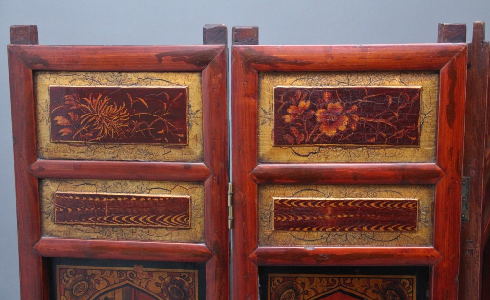 An early 20th-century seven-panel Chinese folding screen featuring crimson and black lacquered sections decorated with hand-painted figures and gilded floral borders. View IX