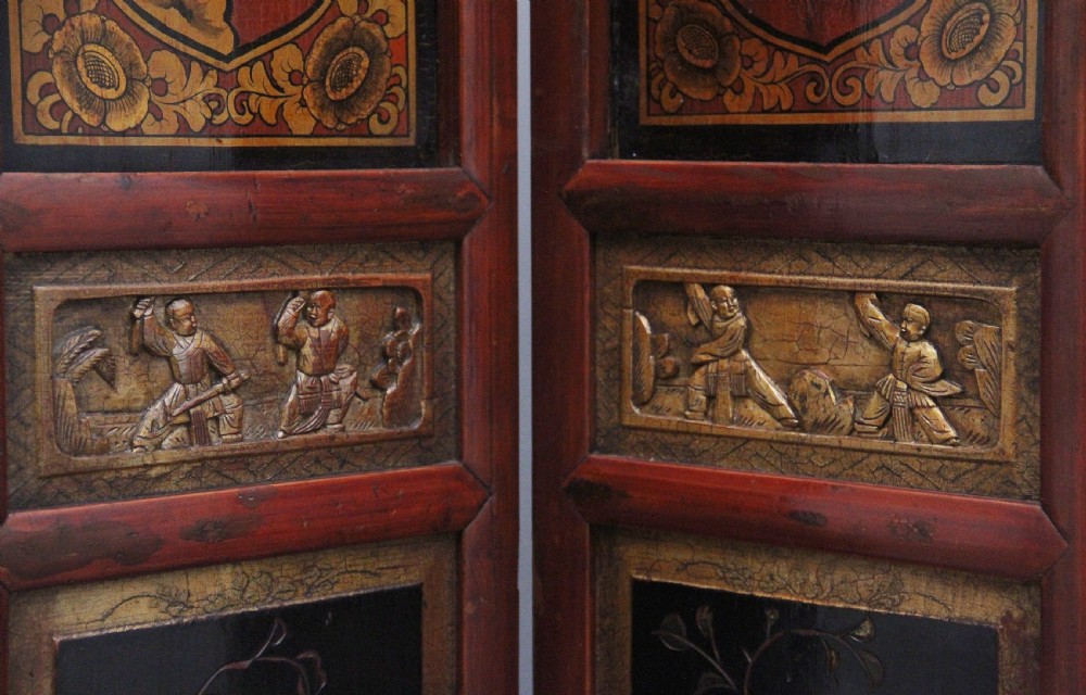 An early 20th-century seven-panel Chinese folding screen featuring crimson and black lacquered sections decorated with hand-painted figures and gilded floral borders. View XII
