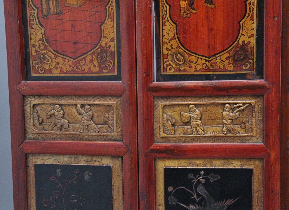 An early 20th-century seven-panel Chinese folding screen featuring crimson and black lacquered sections decorated with hand-painted figures and gilded floral borders. View XV