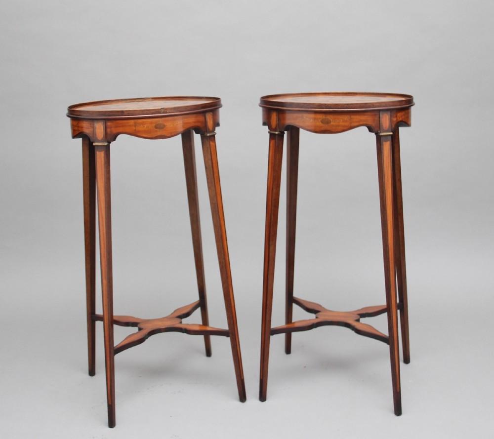 A pair of tall, oval-topped mahogany urn stands featuring central floral marquetry inlays, pull-out slides, square tapered legs, and curved X-form stretchers. View X