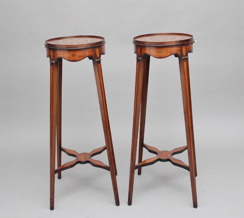 A pair of tall, oval-topped mahogany urn stands featuring central floral marquetry inlays, pull-out slides, square tapered legs, and curved X-form stretchers. View XI