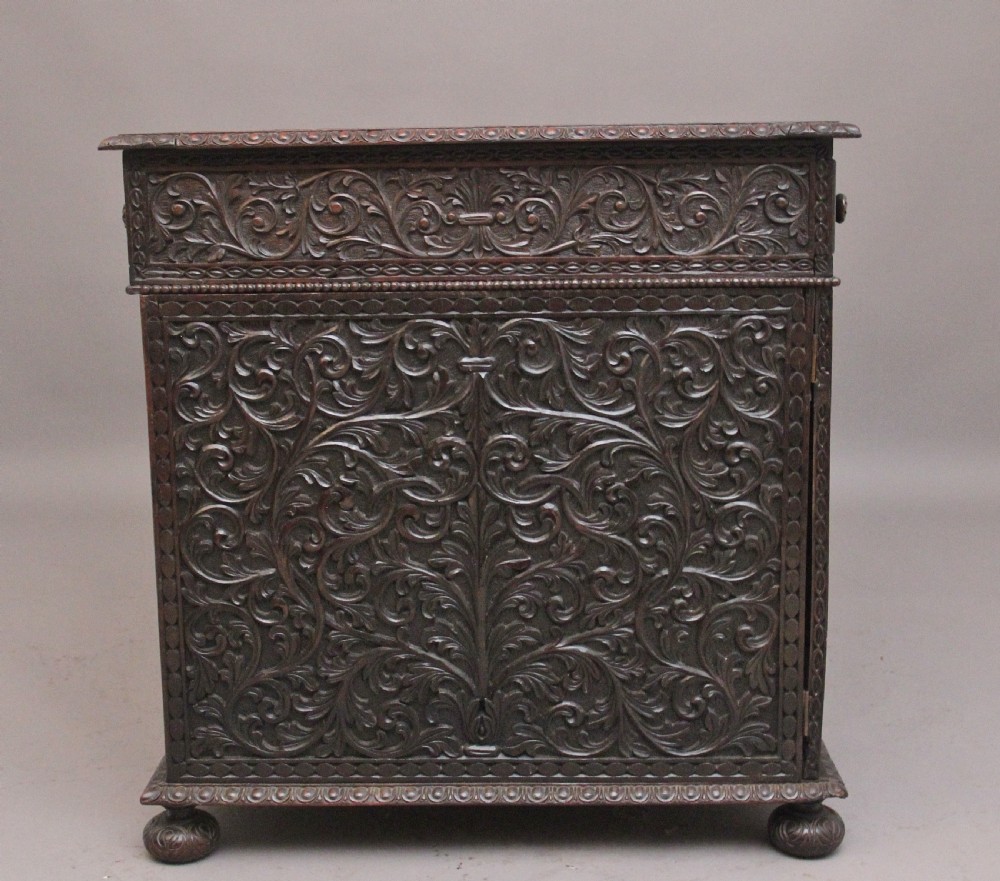 A dark wood double pedestal partners desk featuring intricate relief floral carvings across all drawers, side panels, and top borders. View VI