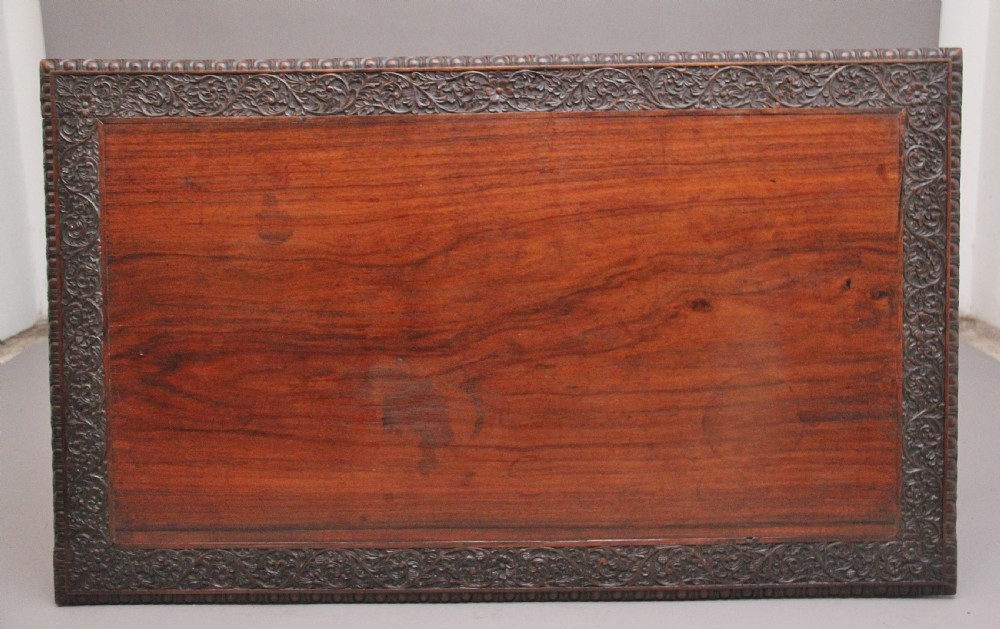 A dark wood double pedestal partners desk featuring intricate relief floral carvings across all drawers, side panels, and top borders. View VII