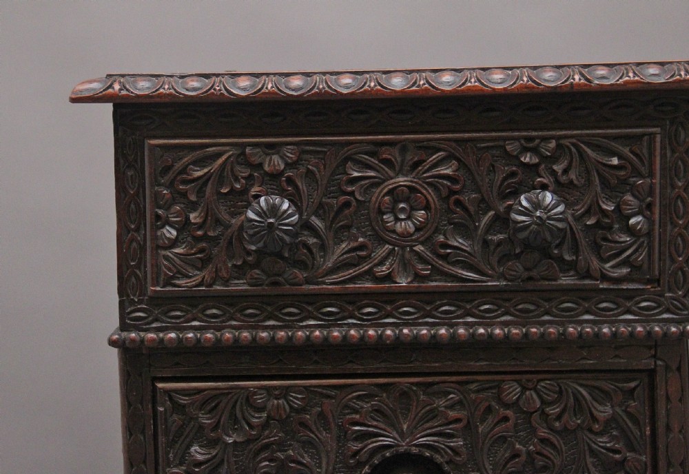 A dark wood double pedestal partners desk featuring intricate relief floral carvings across all drawers, side panels, and top borders. View IX