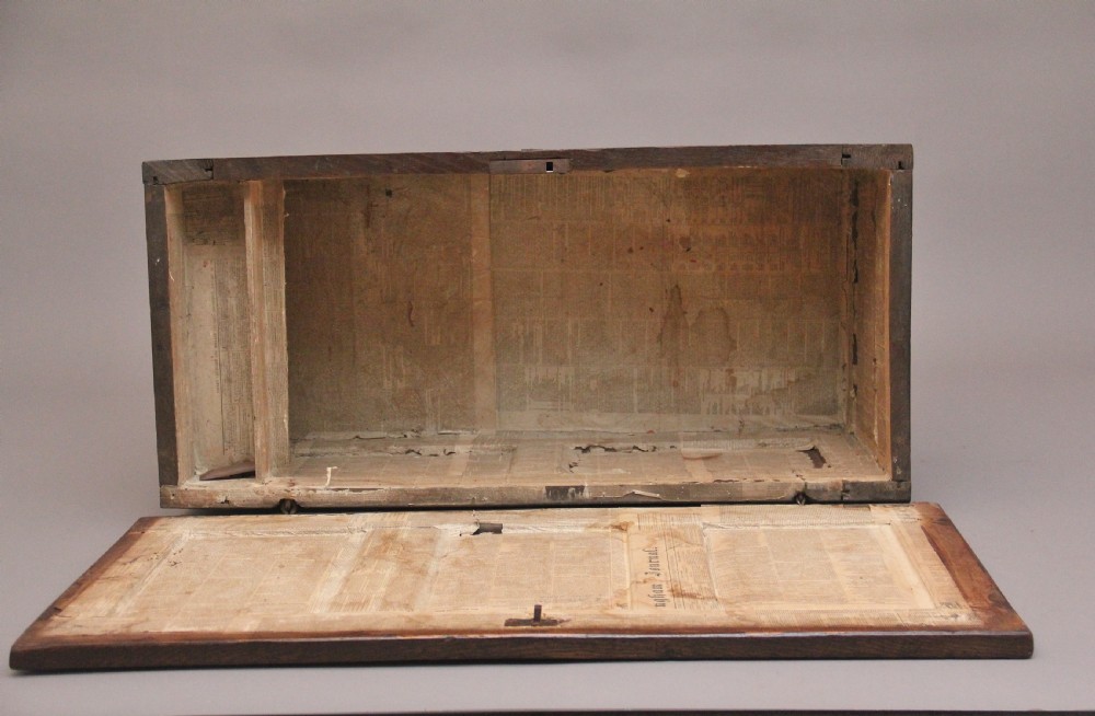 An 18th-century dark oak coffer featuring a three-panel hinged top, twin-panelled front, central keyhole escutcheon, and sturdy stile legs. View IX