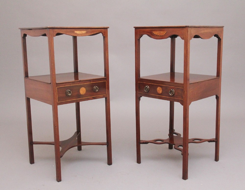 A near pair of tall 19th-century mahogany bedside tables featuring fan marquetry inlay, single drawers with brass ring handles, open upper shelves, and decorative cross-stretchers.