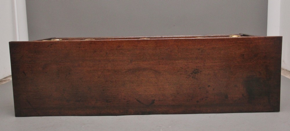 An early 19th-century dark oak dresser base featuring five drawers with brass oval handles, an arched central apron, and a lower potboard shelf. View VII
