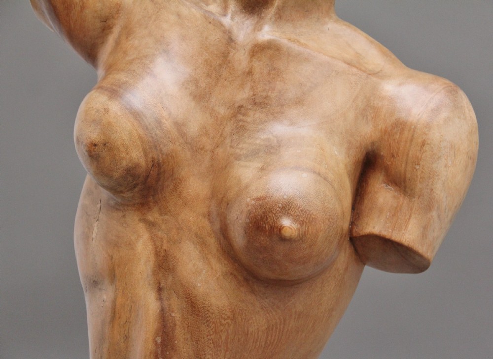 A life-size carved wooden female torso sculpture displayed against a neutral grey background. View IX