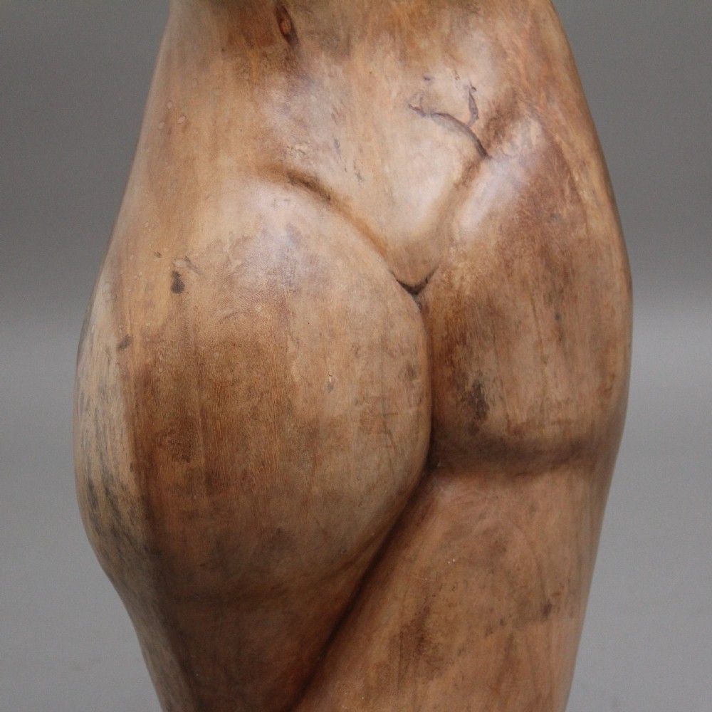 A life-size carved wooden female torso sculpture displayed against a neutral grey background. View XV