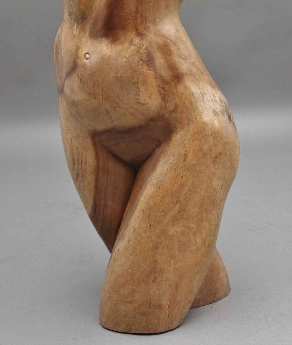 A life-size carved wooden female torso sculpture displayed against a neutral grey background. View XVI