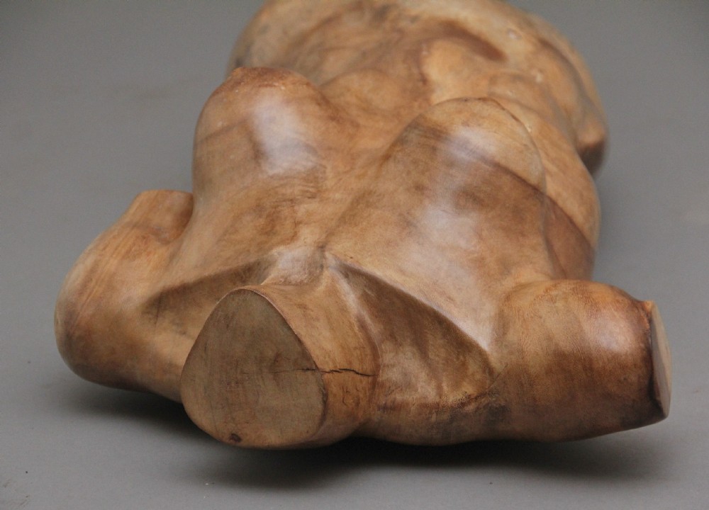 A life-size carved wooden female torso sculpture displayed against a neutral grey background. View XVII