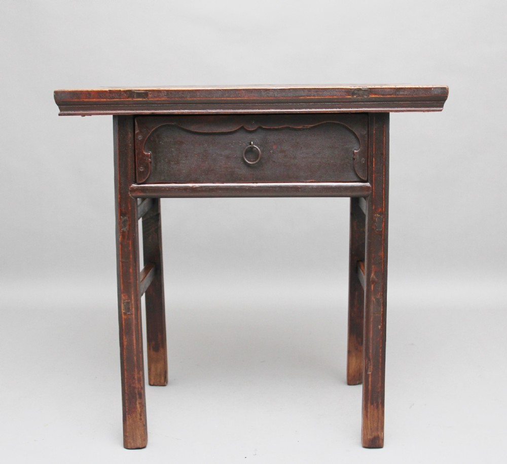 A nineteenth-century dark brown Chinese elm side table featuring a single drawer with a metal ring pull and straight square legs.