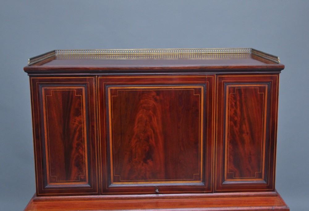 A 19th-century mahogany secretaire desk with open upper cabinet doors, fitted internal pigeonholes, and an extended pull-out writing surface lined in green leather. View VII