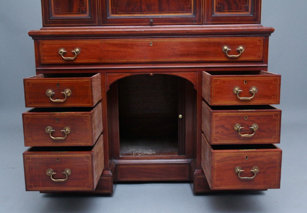 A 19th-century mahogany secretaire desk with open upper cabinet doors, fitted internal pigeonholes, and an extended pull-out writing surface lined in green leather. View IX