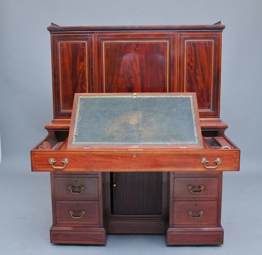 A 19th-century mahogany secretaire desk with open upper cabinet doors, fitted internal pigeonholes, and an extended pull-out writing surface lined in green leather. View X