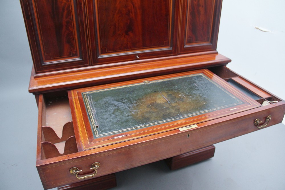 A 19th-century mahogany secretaire desk with open upper cabinet doors, fitted internal pigeonholes, and an extended pull-out writing surface lined in green leather. View XI