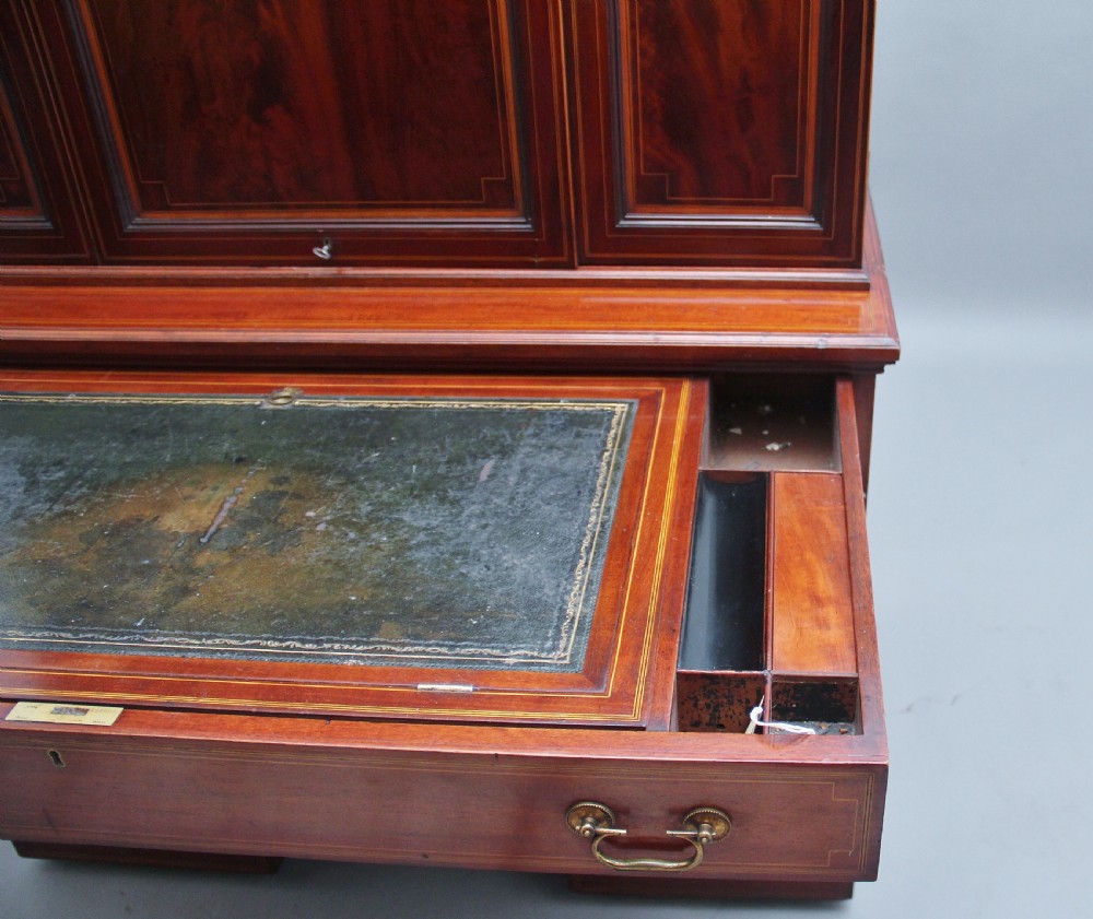 A 19th-century mahogany secretaire desk with open upper cabinet doors, fitted internal pigeonholes, and an extended pull-out writing surface lined in green leather. View XII